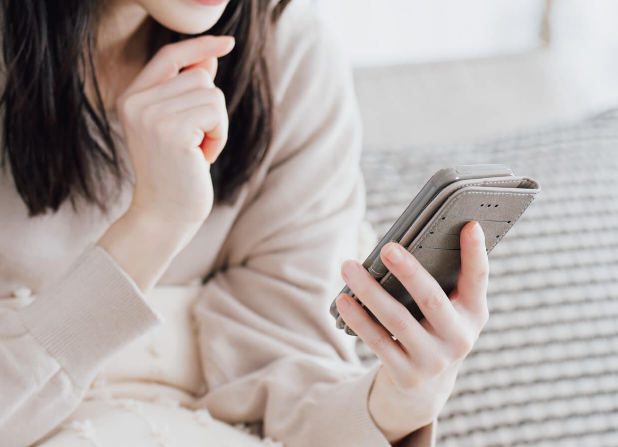 携帯を見て考えている女性