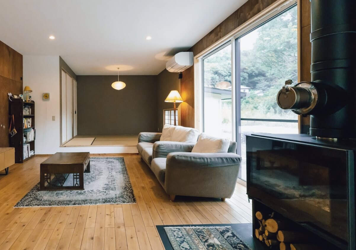 大きな窓から陽の光が入る広いナチュラルモダンなリビング