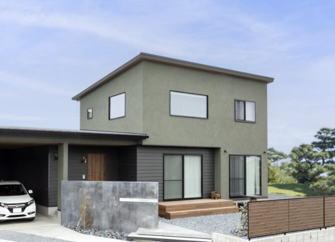 広い庭と駐車場のあるシンプルモダンな家の外観