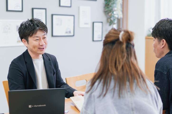 夫婦のお客さんと話し合いをしているスタッフの男性